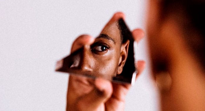 Black woman looking in mirror