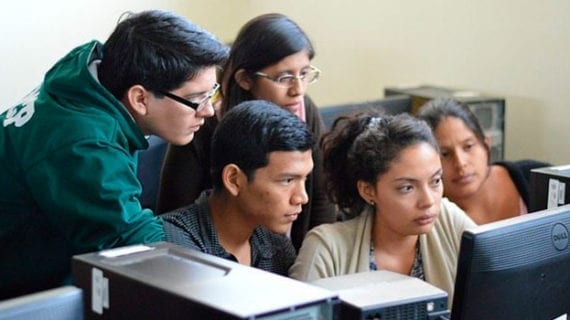 Students looking over shoulder of another student sitting at a computer How to spark entrepreneurship in students