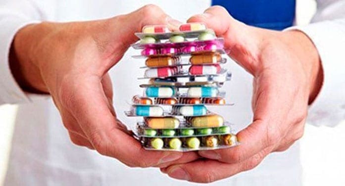 Pharmacist holding handfull of pills regulators, medical