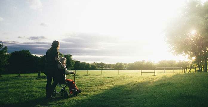wheelchair caregiver sunset nature sunrise service Roots of happiness are found in service to others