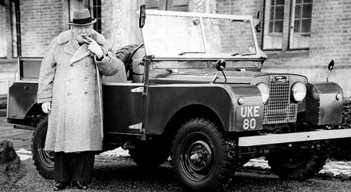 Winston Churchill smoking a cigar besire a jeep during the Second World War
